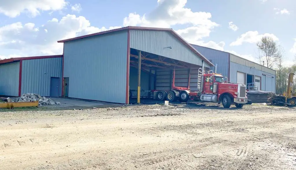 Large commercial steel building with an open bay and a semi truck parked inside